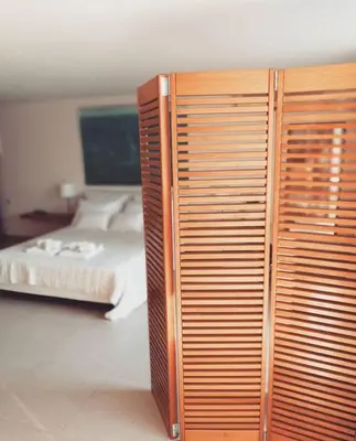 a bedroom with a bed and a wooden cabinet at Couple's Getaway , Modern Amenities & Sophisticated Style in Rhodes Town
