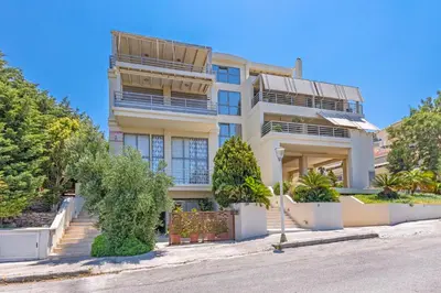 a large white building with trees in front of it at Couple's Getaway , Modern Amenities & Sophisticated Style in Rhodes Town