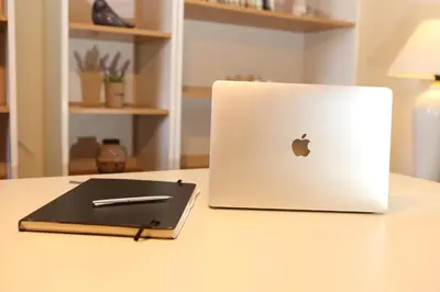 a laptop computer sitting on a table with a pen at Couple's Getaway , Modern Amenities & Sophisticated Style in Rhodes Town