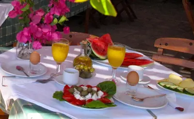 a table with eggs and fruit and drinks on it at Prasonisi Club in Kattavía