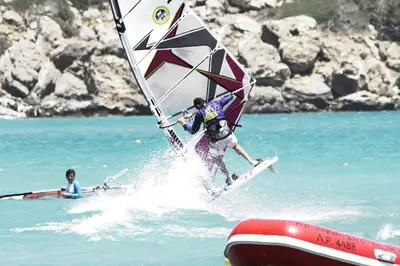 a man in the water on a board with a sail at Prasonisi Club in Kattavía