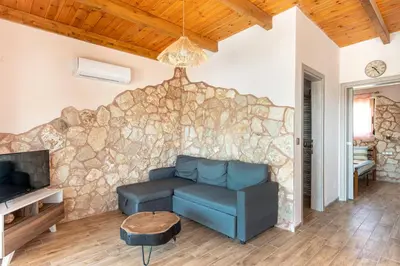 a living room with a couch and a stone wall at Stergios summer dream house in Kolimbia