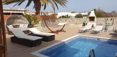 a swimming pool with lounge chairs and a hammock next to a swimming pool at Stergios summer dream house in Kolimbia