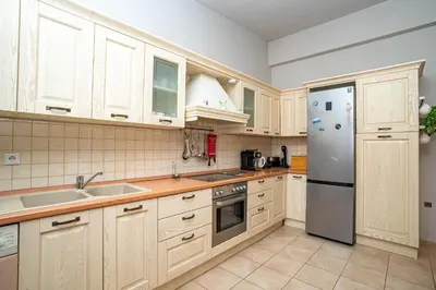 a kitchen with white cabinets and a stainless steel refrigerator at Madia Villa in Kolimbia