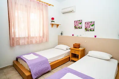 two twin beds in a room with a window at Madia Villa in Kolimbia