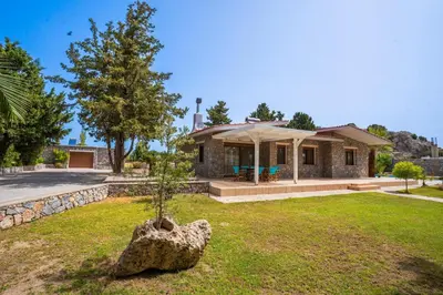 a house with a tree in a yard at Madia Villa in Kolimbia