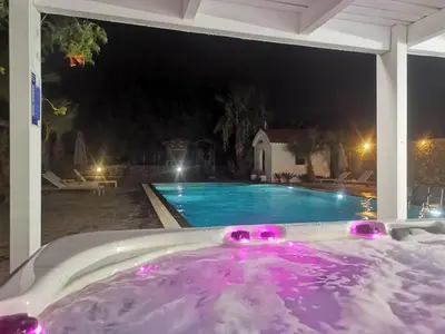 a jacuzzi tub in a backyard at night at Madia Villa in Kolimbia