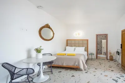 a bedroom with a bed and a table and chairs at KRANA Hotel in Líndos