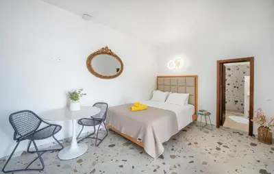 a bedroom with a bed and a table and chairs at KRANA Hotel in Líndos