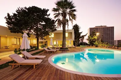 a swimming pool with lounge chairs and a hotel at ABAV2 Suites by Rodos Palace in Ixia