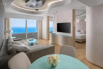 a living room with a couch and a television at ABAV2 Suites by Rodos Palace in Ixia