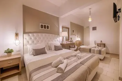 a large bedroom with two beds and a desk at Kokona in Symi