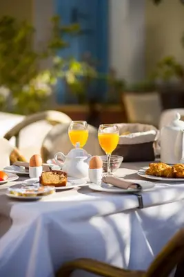 a table with eggs and two glasses of orange juice at Kokona in Symi