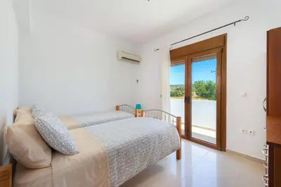 a bedroom with a bed and a sliding glass door at Cosy House in Kiotari with Garden and Terrace in Kiotari