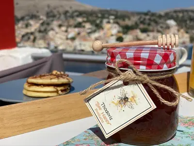 a jar of honey next to a plate of cookies at Thodoris Infinity View Apartments in Symi