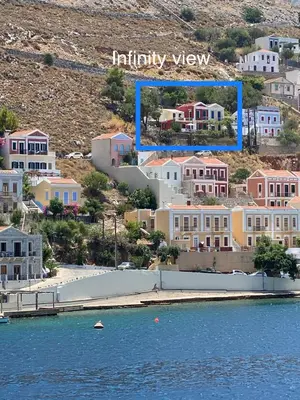 an aerial view of a town with houses and water at Thodoris Infinity View Apartments in Symi