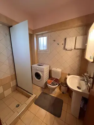 a bathroom with a toilet and a sink and a washing machine at Apartment 29 in Rhodes Town