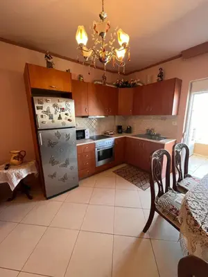 a kitchen with a refrigerator and a table and a chandelier at Apartment 29 in Rhodes Town