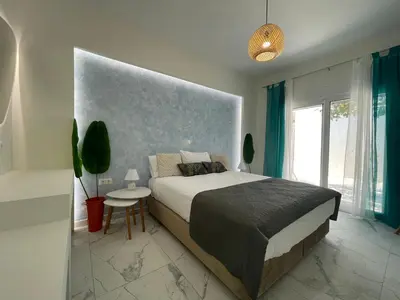 a bedroom with a large bed and a table at The Sky Yard Eclectic Studios in Rhodes Town