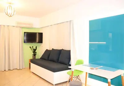 a living room with a couch and a table at The Sky Yard Eclectic Studios in Rhodes Town
