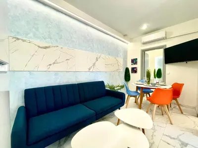 a living room with a blue couch and a table at The Sky Yard Eclectic Studios in Rhodes Town