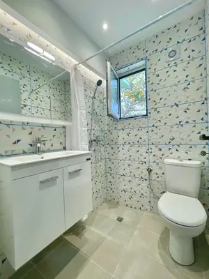 a bathroom with a toilet and a sink and a window at The Sky Yard Eclectic Studios in Rhodes Town