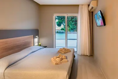 a bedroom with a bed with towels on it at Sunday Hotel in Ialyssos