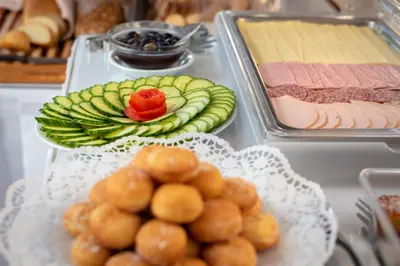 a buffet of food with cucumbers and meat and vegetables at Sunday Hotel in Ialyssos