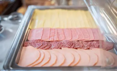 a tray of hot dogs and meat in a refrigerator at Sunday Hotel in Ialyssos