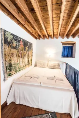 a bed in a room with a painting on the wall at Villa Mika in Líndos
