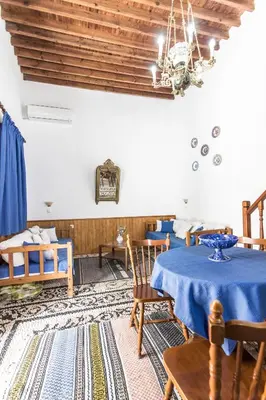 a dining room with a blue table and chairs at Villa Mika in Líndos