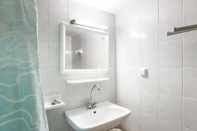 a white bathroom with a sink and a mirror at Villa Mika in Líndos