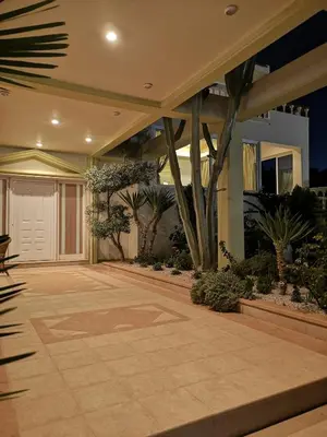 a house with a courtyard with trees and plants at Louis Luxury Villa by living in blue in Rhodes Town