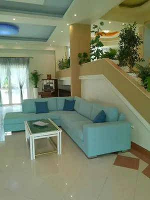 a living room with a blue couch and a staircase at Louis Luxury Villa by living in blue in Rhodes Town