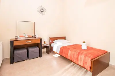 a bedroom with a bed and a dresser and a mirror at Cozy Family Home steps from the Beach in Afantou