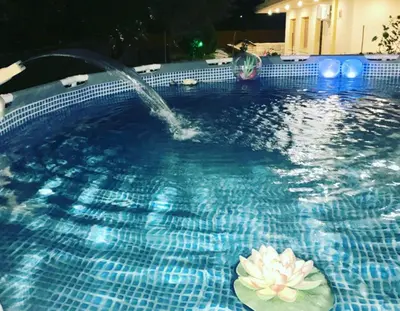 a pool with a water fountain with a flower in it at Cozy Family Home steps from the Beach in Afantou