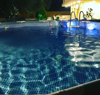 a swimming pool at night with a water slide at Cozy Family Home steps from the Beach in Afantou