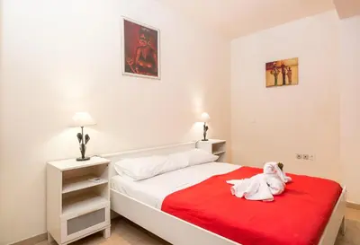 a bedroom with a bed with a red blanket at Cozy Family Home steps from the Beach in Afantou