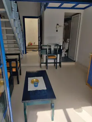 a living room with a table and chairs and stairs at Blue Sky Aparts in Livadia