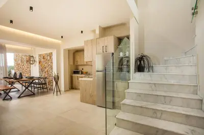a kitchen and dining room with stairs in a house at Venezia Luxury Living Villas, Faliraki in Faliraki