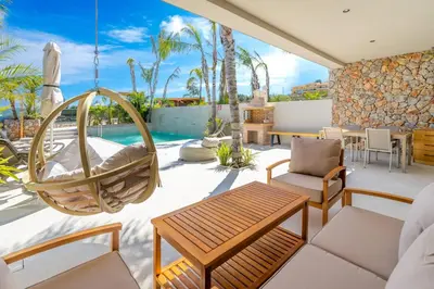 an outdoor patio with a swinging chair and a hammock at Venezia Luxury Living Villas, Faliraki in Faliraki