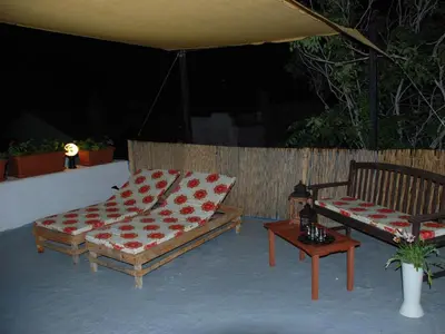 two beds and a table on a patio at Medieval Inn in Rhodes Town