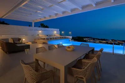 a dining area with a table and chairs and a pool at Villa Mimosa in Pefkos (Lindos area) in Líndos