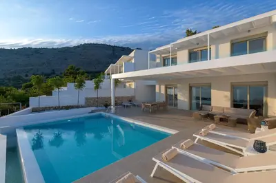 a villa with a swimming pool and a house at Villa Mimosa in Pefkos (Lindos area) in Líndos
