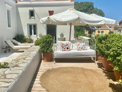 a patio with a couch and an umbrella at Villa Panorama in Symi