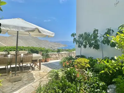 a patio with an umbrella and a table and chairs at Villa Panorama in Symi