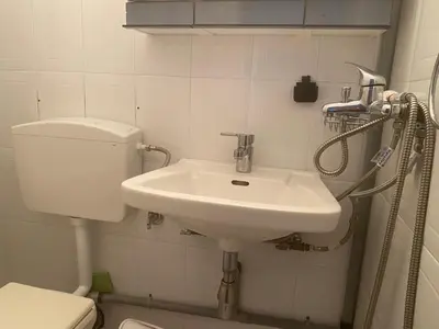 a bathroom with a white sink and a toilet at Villa Panorama in Symi