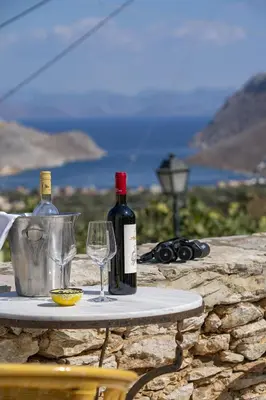 a table with two bottles of wine and two glasses at Villa Panorama in Symi