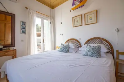 a bedroom with a large white bed with blue pillows at Villa Panorama in Symi