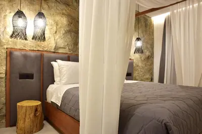 a bedroom with a bed and two pendant lights at Rafael Hotel-Adults Only in Líndos